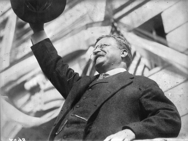President Theodore 'Teddy' Roosevelt salutes a crowd during a public appearance