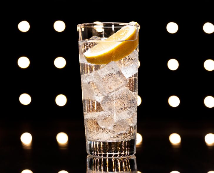 A Tom Collins with lemon wedge