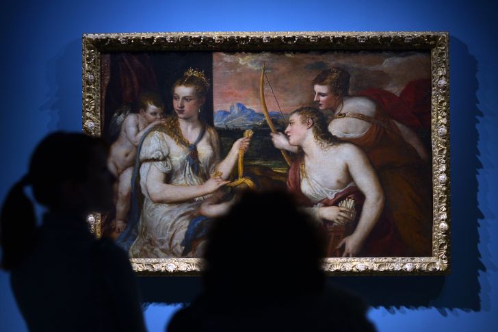 Visitors look at a painting by Renaissance master Titian in Rome