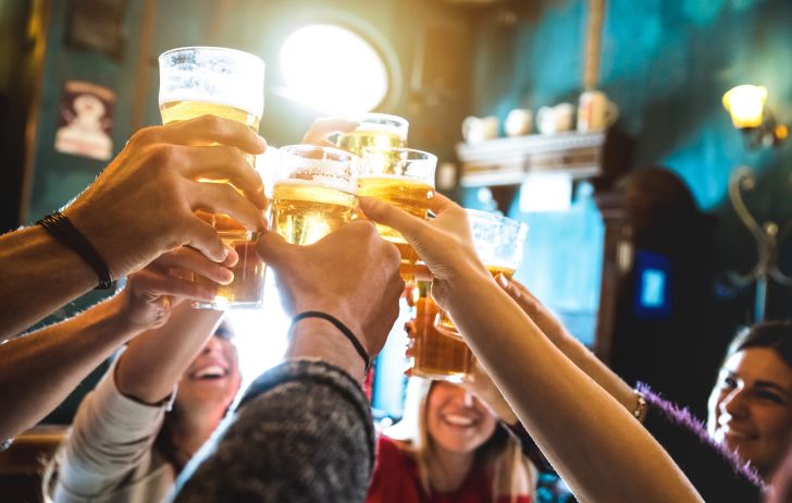 Friends share a celebratory toast with pints of beer