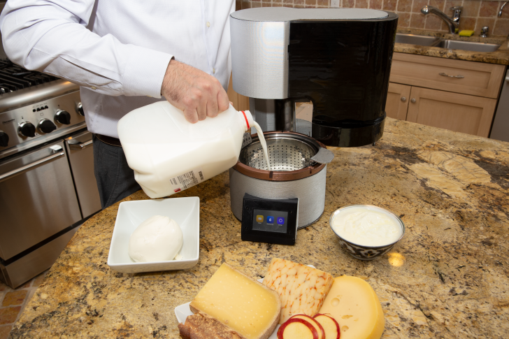 Pouring milk into home cheesemaking machine.