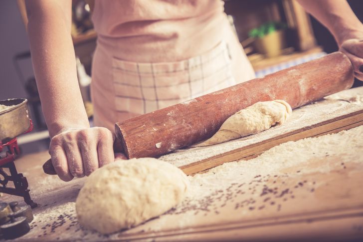 A baker rolls bread dough
