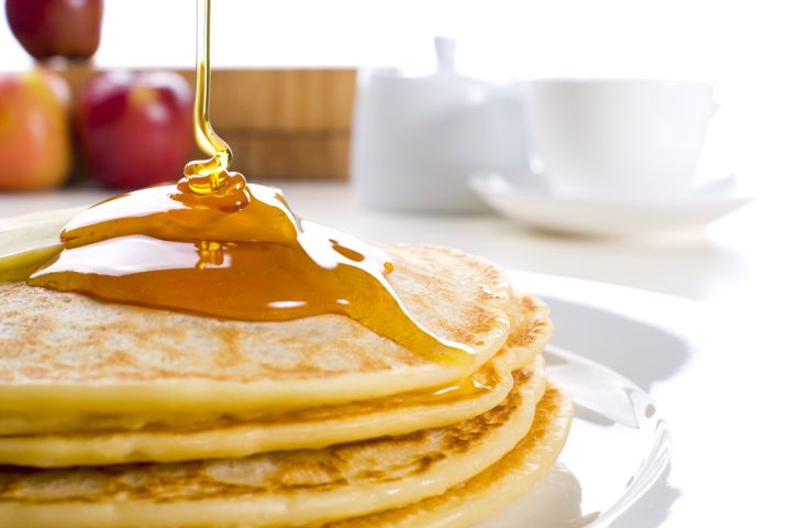 Drizzling syrup over pancakes