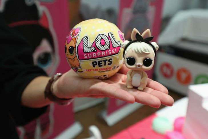 A woman holds a L.O.L. Surprise doll and packaging in her hand