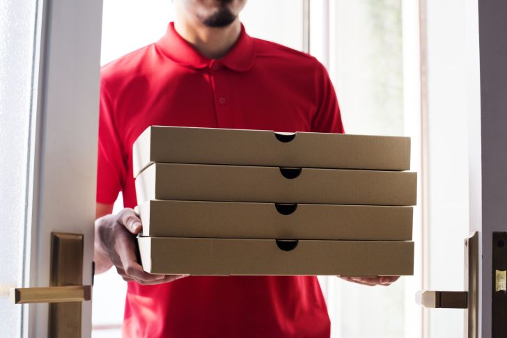Man delivers several pizzas to a customer