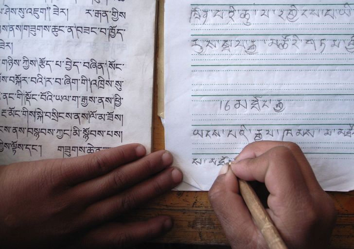 A student writes the Tibetan script