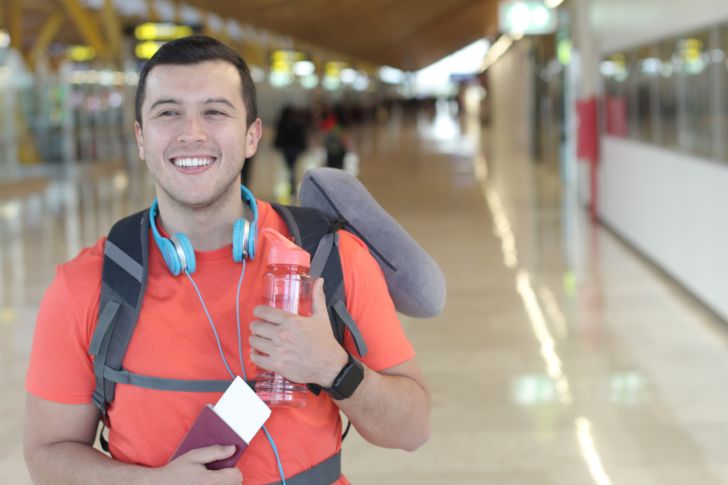 A man holds a water bottle at the airport