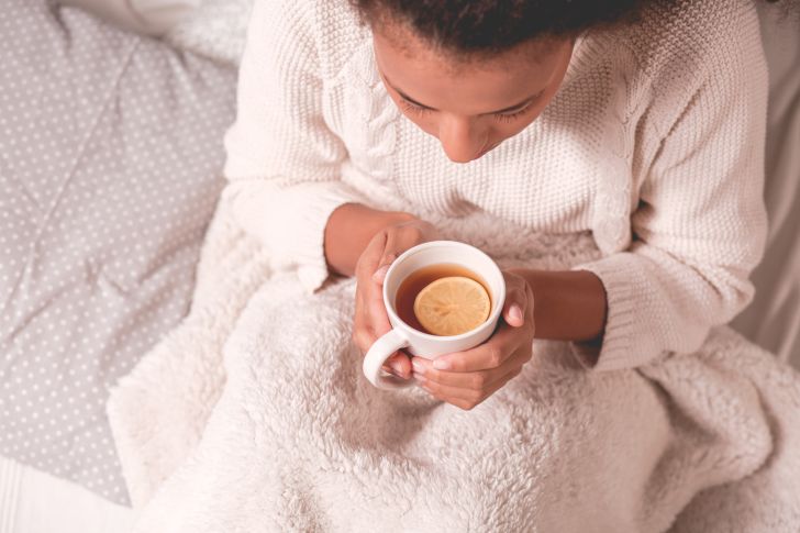 Woman in a sweater holding a cup of tea Woman in a sweater holding a cup of tea