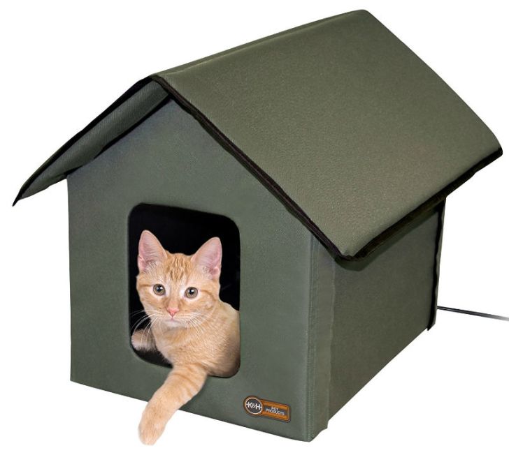 A cat sits inside a K&H heated cat house