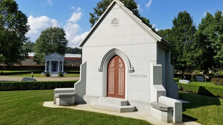 A mausoleum in a graveyard on a sunny day