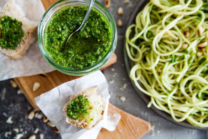 Pesto in cup with bread and pasta.