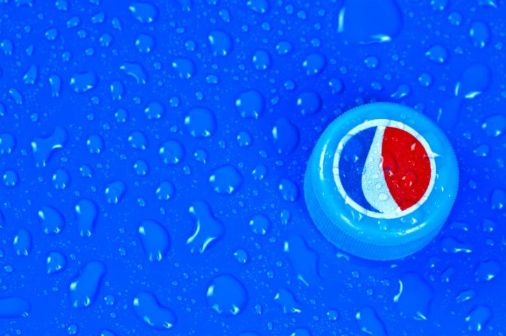 A Pepsi bottlecap is pictured against a blue background