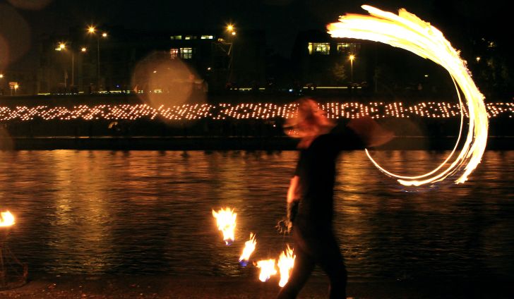 People light candles during the autumn equinox celebration at Neris River waterfront in Vilnius, Lithuania after sunset on September 21, 2013.