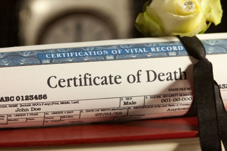A death certificate sits on top of a table
