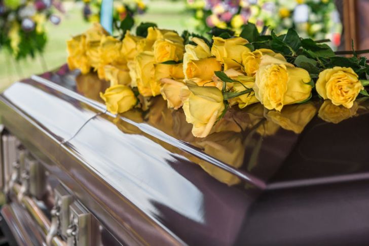 Yellow flowers sit on top of a coffin