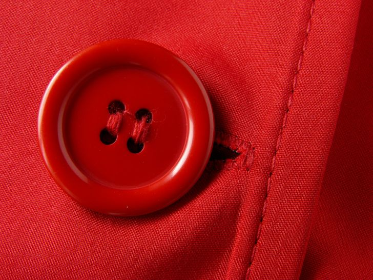 A red button appears on red fabric