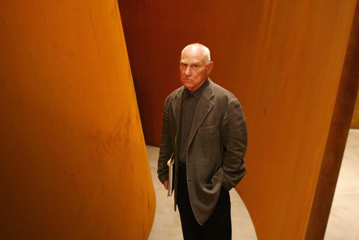 Richard Serra standing with his work.