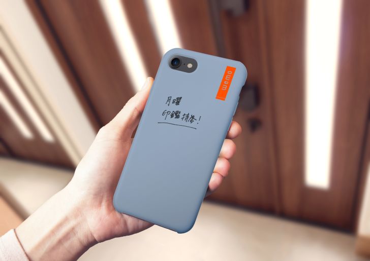 Hand holding phone with text written on it.