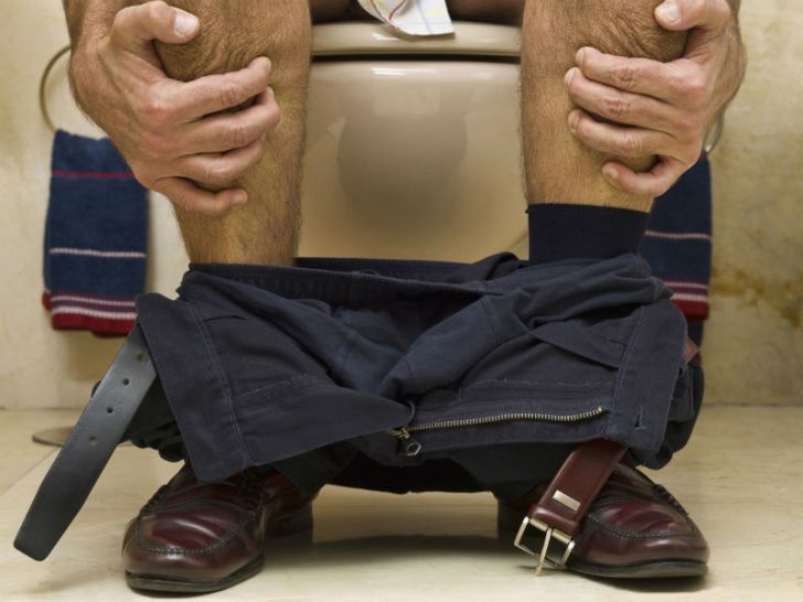A man strains while using the toilet