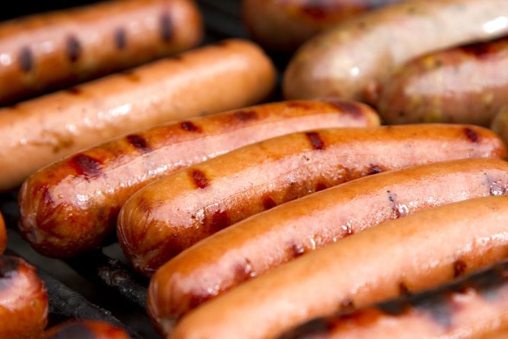 Image of hot dogs being cooked on a grill