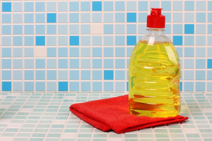 A bottle of dish soap against a tiled background