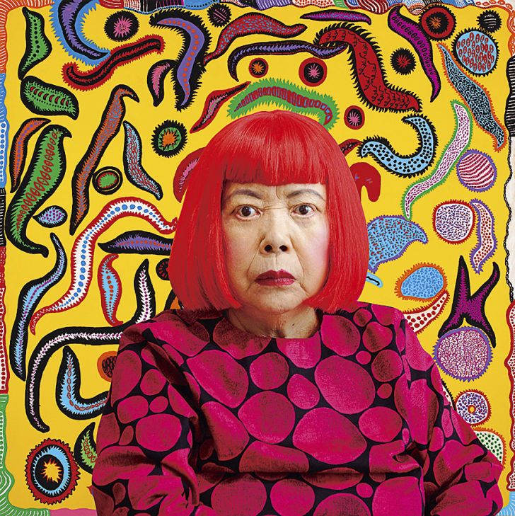A portrait of Yayoi Kusama wearing a red wig