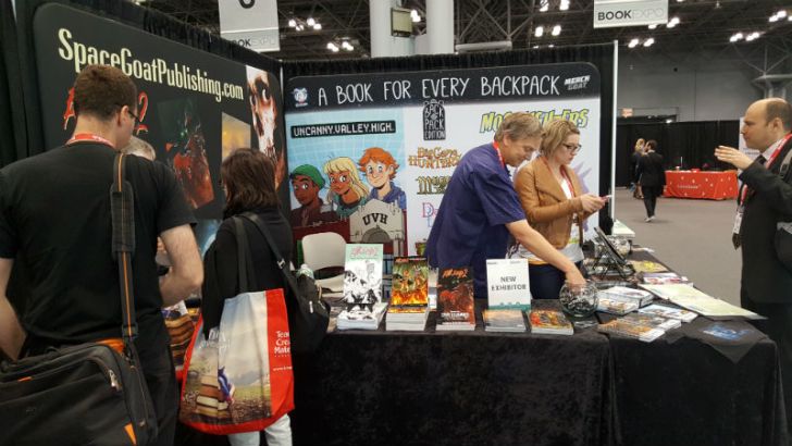 Visitors stop by a Space Goat Productions convention table