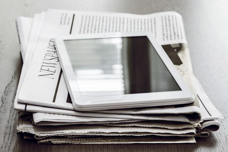 newspaper stack of newspapers and tablet