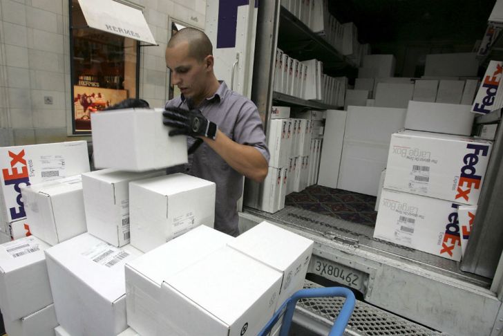 A FedEx driver stacks packages