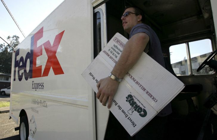 A FedEx driver carries a package