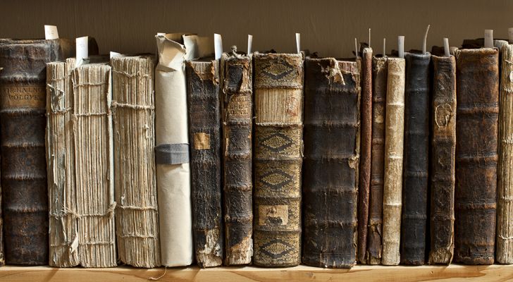 A shelf of older books, some with damaged covers A shelf of older books, some with damaged covers