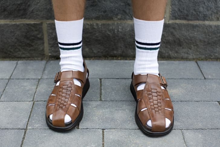 Photo of man in white socks and sandals.