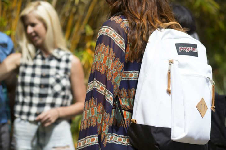 A woman wears a white JanSport backpack