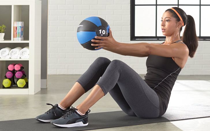 A woman using a medicine ball to exercise