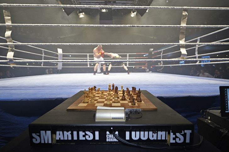 A chess board awaits two boxers between rounds
