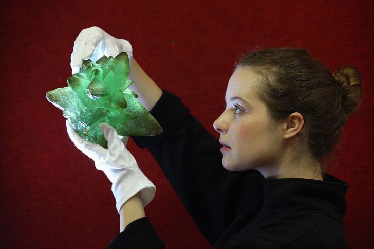 An employee at Bonhams auction house holds a 'Kryptonite' prop crystal from the film 'Superman III',