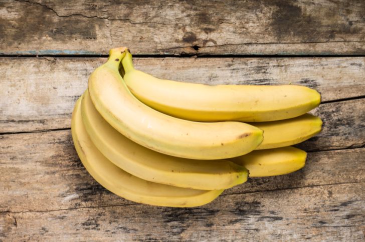 A bunch of bananas on a wooden background