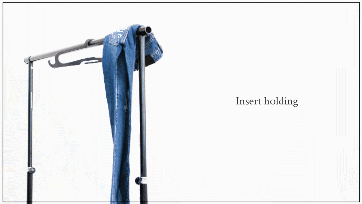 A person slides the Hurdle Hanger through the belt loops of a pants to hang them.
