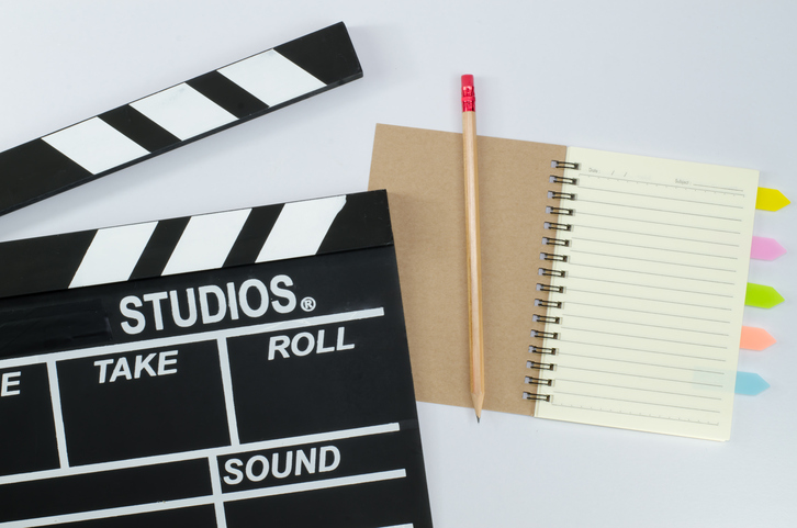 Slate film and notebook on a white background.